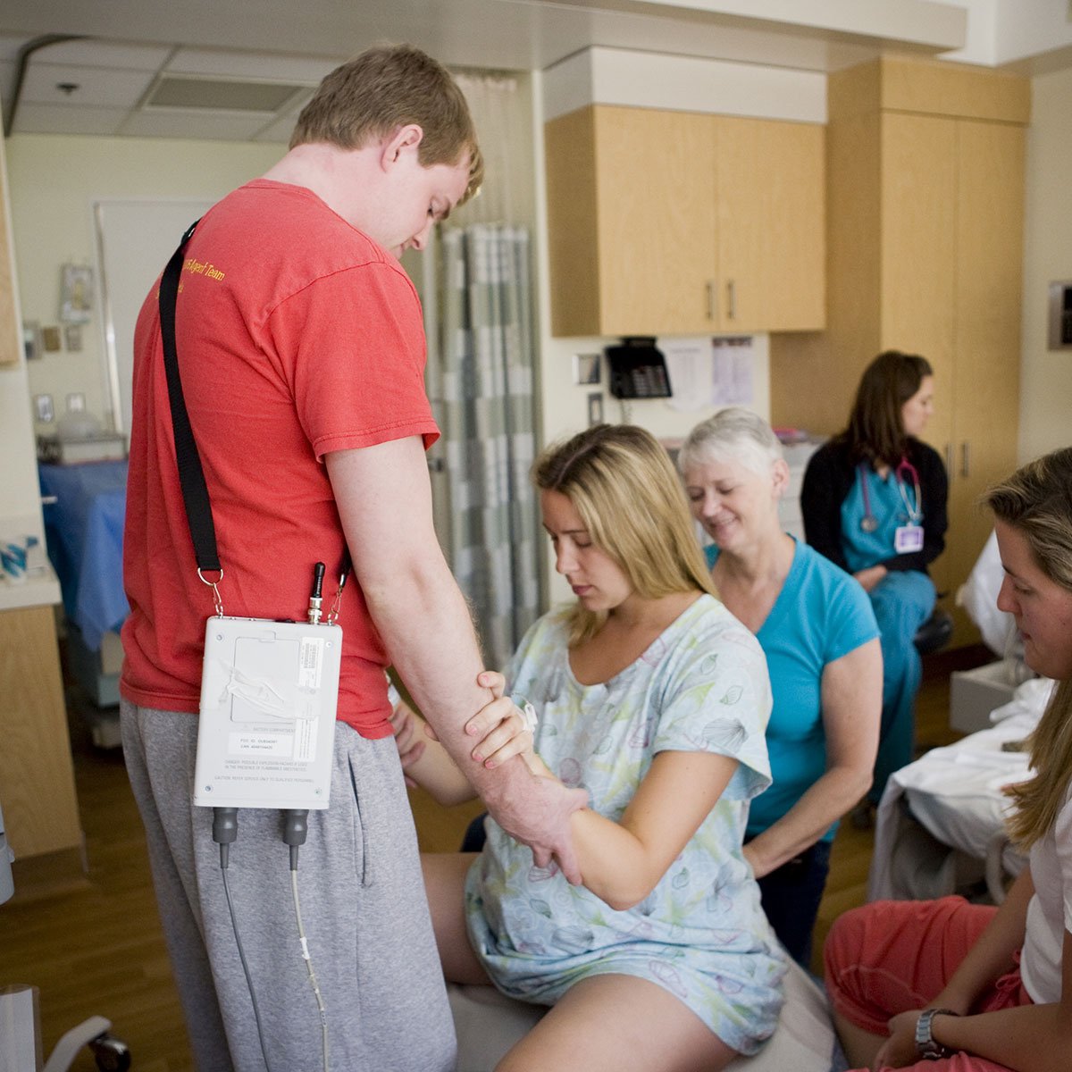 doula and family helping laboring person Birth ball exercises while in labor